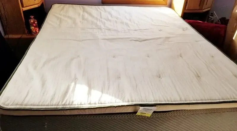 Mattress with a plush topper layer on a bed frame