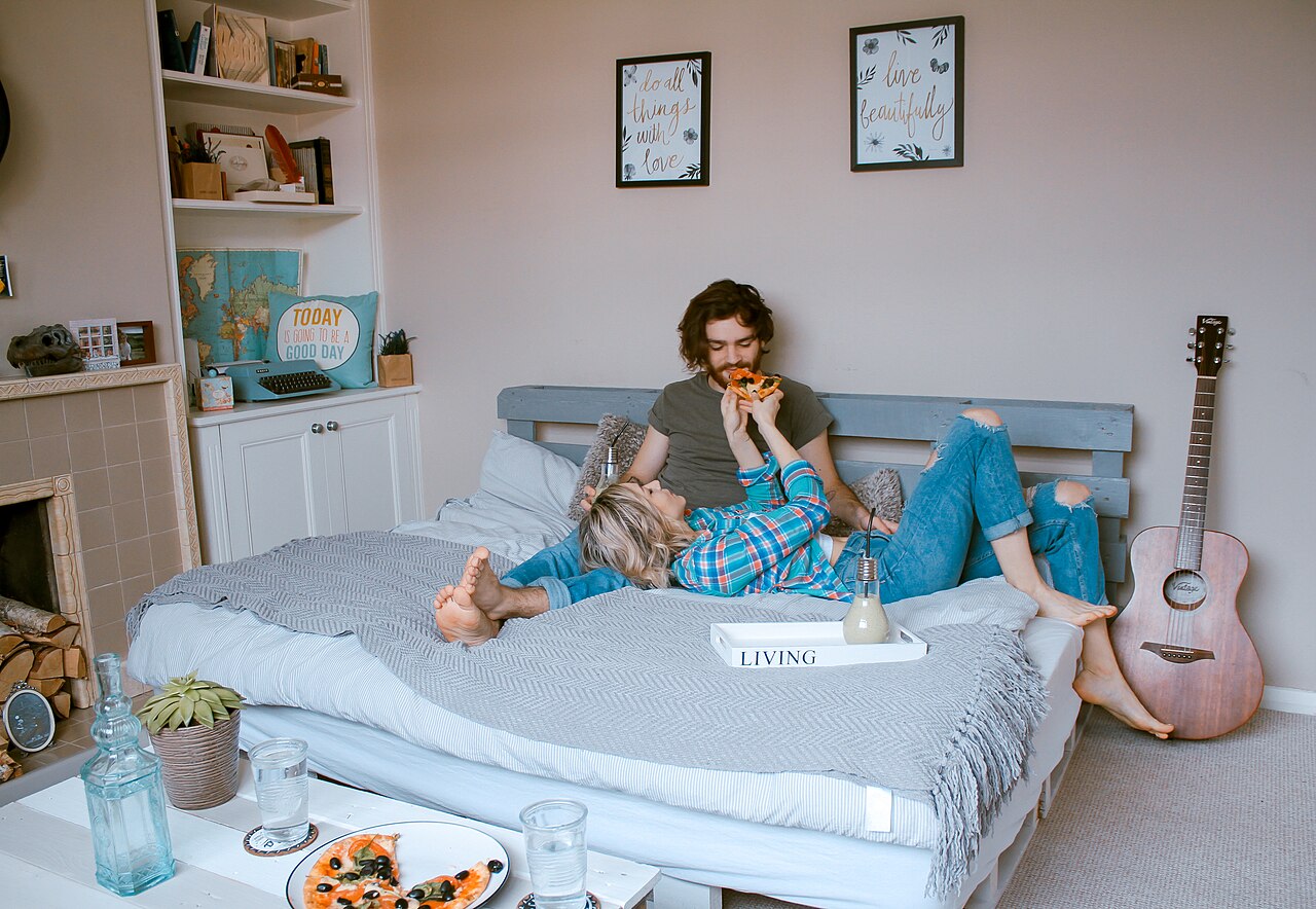 Couple relaxing together on a comfortable bed in a cozy bedroom